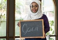 Islamic woman small business owner holding blackboard with smiling Royalty Free Stock Photo