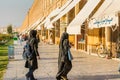 Islamic women tourists walking pass by the shops situated inside of Naqsh-i Jahan Square , an important historical site
