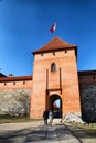 Island castle in Trakai and tourist near it. One of the most popular touristic destinations in Lithuania in early spring Royalty Free Stock Photo