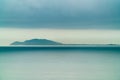 An Island in the distance lies in the calm sea, Sky BLue Color, banner