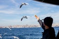 Island Ferry Ada Vapuru. Some of the ferry passengers feed seagulls. Passenger ferryboats from Istanbul sail regularly to the Pr