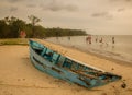Island life: abandoned blue fishing boat rests on the shore
