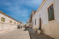 A quiet, empty street in the beach town of Ilha de Mocambique on a sunny day.