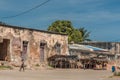 A weathered building and empty market stalls on a quiet street on Ilha de