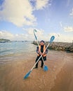 Muslim woman wearing burqini and life jacket is holding the kayak paddle by the beach in an island Royalty Free Stock Photo