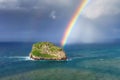 Island named Aketxe in Bermeo with stormy clouds and a rainbow Royalty Free Stock Photo