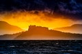 Island of Procida, Campania region, Italy. Image of the island at sunset with a castle silhouette seen from a beach with twilight Royalty Free Stock Photo
