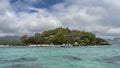 The island in the turquoise Indian Ocean is overgrown with tropical vegetation. Royalty Free Stock Photo