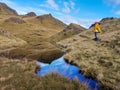Isle of Skye, United Kingdom - 18 OCTOBER 2019 : A hiker looking over amazing landscape in Old Man of Storr.