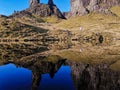 Isle of Skye, United Kingdom - 18 OCTOBER 2019 : A traveler standing across small lochan in amazing landscape in Old Man of Storr.