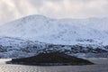 islet with snowy mountains in scottish highlands with cloudy sky Royalty Free Stock Photo