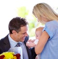 Isnt dad the sweetest. Young businessman bringing flowers home to his beautiful family. Royalty Free Stock Photo