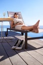 Isnt this the life...a well-dressed woman lying on a poolside deck chair. Royalty Free Stock Photo