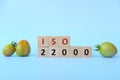 ISO 22000 or Food Safety Management System on wooden blocks in blue background.