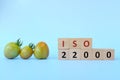 ISO 22000 or Food Safety Management System on wooden blocks in blue background.