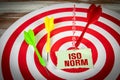 ISO NORM. Piece of paper with text and a dart in the middle of the target