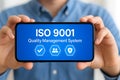ISO 9001 quality management system certification on smartphone screen Royalty Free Stock Photo