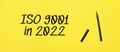 ISO 9001 in 2022 sign with black marker on a yellow background. With copy space ready for your text