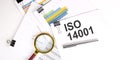 ISO 14001 text on white paper on light background with charts paper