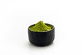 Isolate Heap Green Tea Powder in black ceramic bowl. Extract Tea Leaves in dark stone cup. Royalty Free Stock Photo