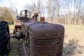 Isolated antique agricultural tractor, partially covered in rust, resting on a grassy field Royalty Free Stock Photo