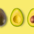 Isolated avocado on a yellow background, trimmed. avocado fruit and two halves in a row, isolated on yellow background, nutrition Royalty Free Stock Photo