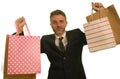 Isolated background portrait of young attractive and happy business man in suit and tie holding lot of shopping bags smiling Royalty Free Stock Photo