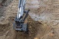 Backhoe scooping dirt out of a hole