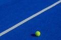 Isolated ball on a blue paddle tennis court