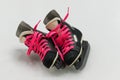 Isolated black old-fashion hockey skates with pink bootlace