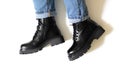 Isolated black unisex boots for winter and autumn with round toe, block heel and embossed hard sole on someone feet with