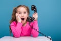 Attractive little cute girl in pink shirt with monkey and blue trousers hold empty poster and talks a phone Royalty Free Stock Photo