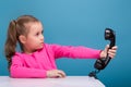 Attractive little cute girl in pink shirt with monkey and blue trousers hold empty poster and talks a phone Royalty Free Stock Photo