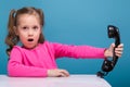 Attractive little cute girl in pink shirt with monkey and blue trousers hold empty poster and talks a phone Royalty Free Stock Photo