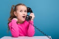 Attractive little cute girl in pink shirt with monkey and blue trousers hold empty poster and talks a phone Royalty Free Stock Photo