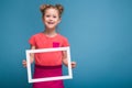 Beautiful cute little girl in pink dress holds picture frame Royalty Free Stock Photo