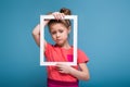 Beautiful cute little girl in pink dress holds picture frame Royalty Free Stock Photo