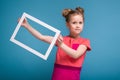 Beautiful cute little girl in pink dress holds picture frame Royalty Free Stock Photo