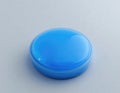 Isolated Blue Push Button on a Light Gray Textured Surface Royalty Free Stock Photo