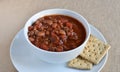 Isolated bowl of chili soup with whole wheat saltine crackers. Royalty Free Stock Photo