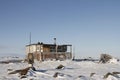 Isolated cabin on snowy ground with a small Inukshuk in front Royalty Free Stock Photo