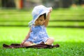 Isolated candid portrait of sweet and adorable Asian Chinese baby girl 3 or 4 months old playing with hat alone at city park