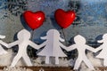 Isolated Chain of Origami Paper Boys and Girls Holding Hands With a Red Heart Between Them and the Hoarfrost on Window in