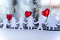 Isolated Chain of Origami Paper Boys and Girls Holding Hands With a Red Heart Between Them and the Hoarfrost on Window in