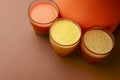 Isolated citrus juice. Three glasses with orange, grapefruit and lemon juice isolated on orange background