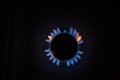 Isolated close up shot of a blue and orange circular fire with small flames on the perimeter coming from a kitchen gas stove and