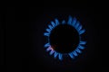 Isolated close up shot of a blue and orange circular fire with small flames on the perimeter coming from a kitchen gas stove and