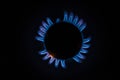 Isolated close up shot of a blue and orange circular fire with small flames on the perimeter coming from a kitchen gas stove and Royalty Free Stock Photo