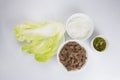  close up top view shot of a bowl of sliced beef fillet pieces, a plate of cellophane glass noodles, a cup of Vietnamese