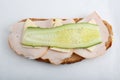 Isolated close up top view shot of a single white bread turkey ham and cheese sandwiches with a slice of cucumber on top on a Royalty Free Stock Photo